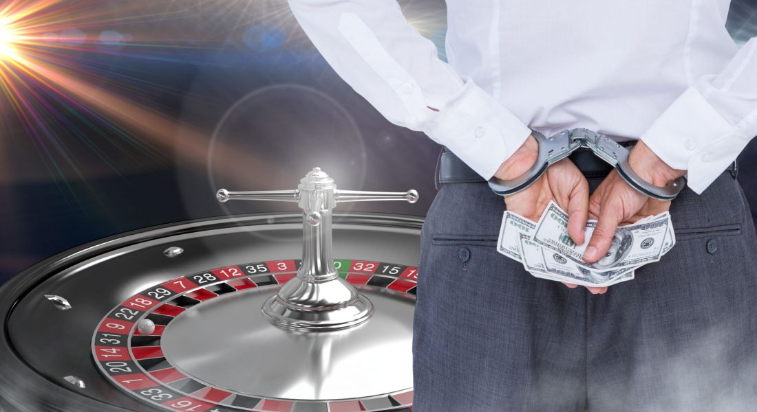 Digital composite of Man in hand cuffs with money and 3d roulette machine